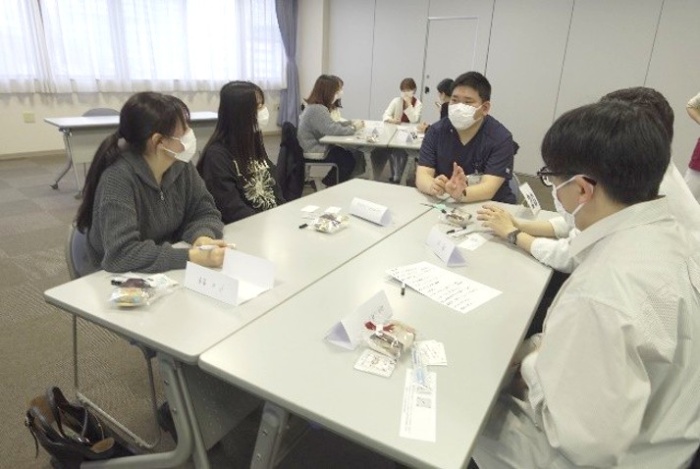 5人の新人看護師が向かい合わせに座り交流している様子