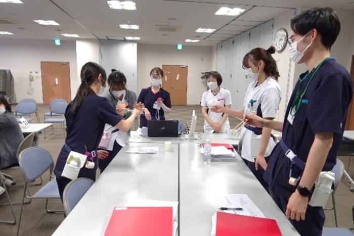 テーブルが4つ、それぞれに5名ずつ程度座り、向かい合ってこれまでの振り返りをしているようす